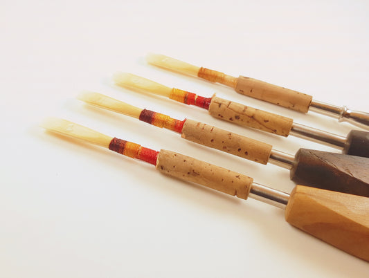 Four oboe reeds on mandrels